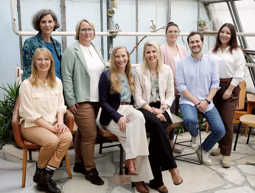 Team von der Koordinationsstelle sitzend und stehend als Gruppenphoto.